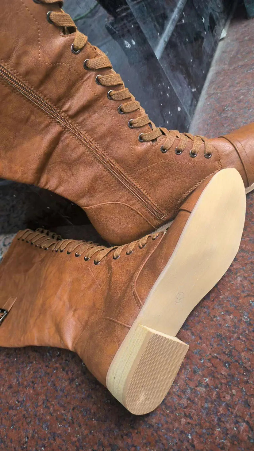 Women's black cross strap knight ankle boots with front laces and side buckle on a solid colour background.