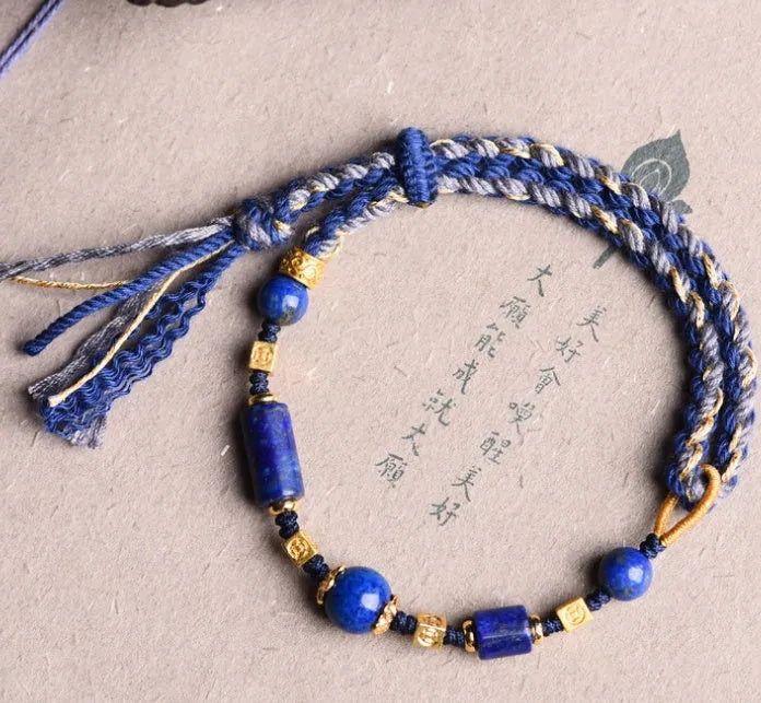 Hand-woven lapis lazuli flexible wire bracelet with simple ethnic design on white background