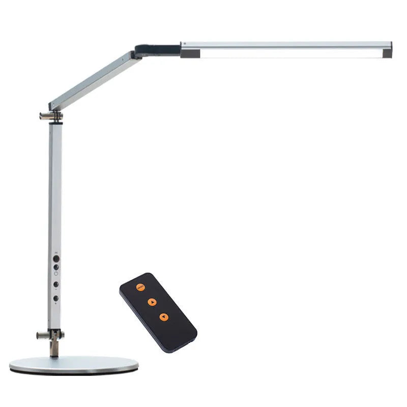 Black clip-on LED desk lamp with remote control attached to a desk edge, showing its folding arm.