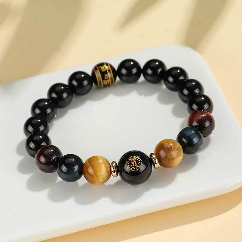 Black agate beaded bracelet with tiger eye stones in ethnic style on plain background
