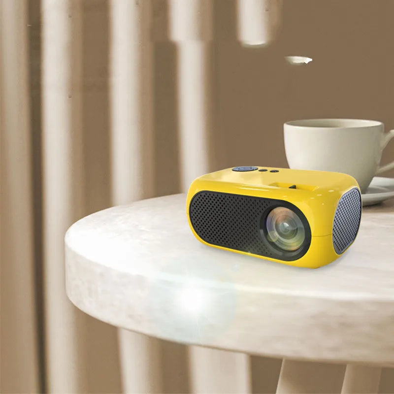 M24 micro mini portable LED projector in gold or white colour on a dark surface