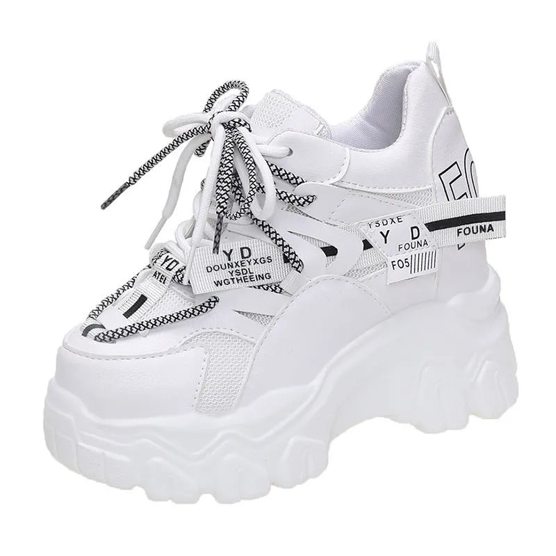 Women's white mesh platform trainers with cross strap and rubber sole showing side profile