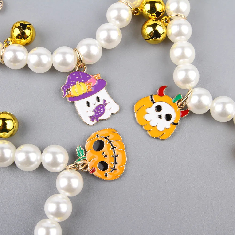 Three pearl necklaces with bells for pets laid out for Halloween costume decoration