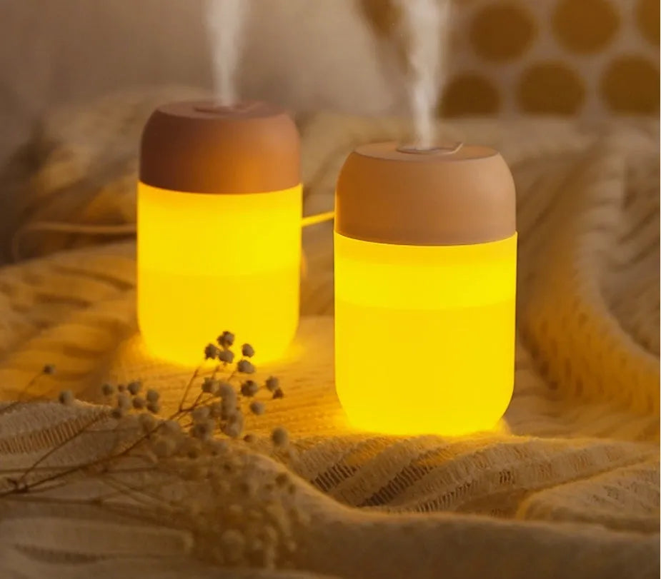 Small white cylindrical USB-powered humidifier with aromatherapy function on a desk