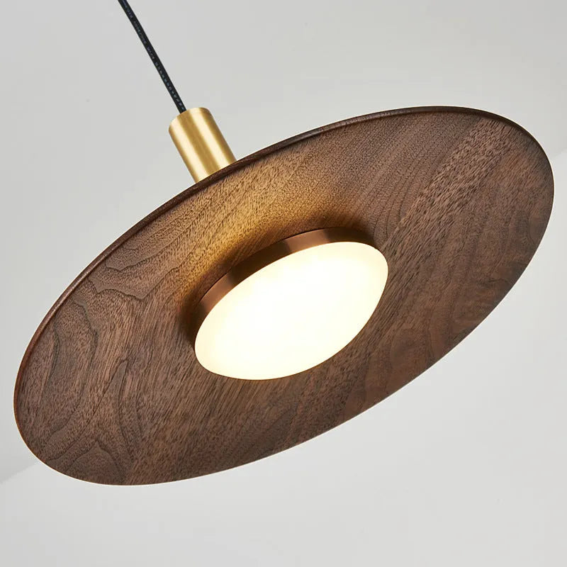 Walnut wood fish line chandelier with all-copper accents against a light background