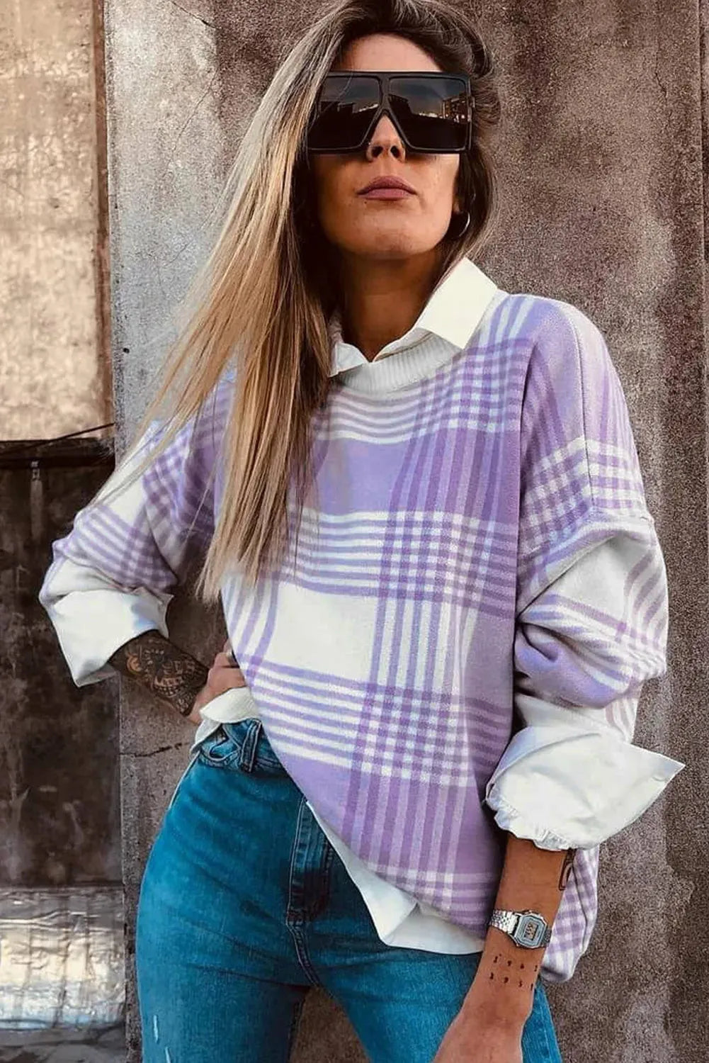Lilac plaid print loose sweater with ribbed trim and long sleeves on a hanger