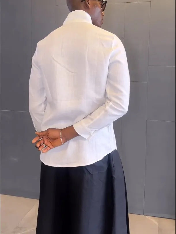 White asymmetric front long sleeve shirt and black pleated pants set on display