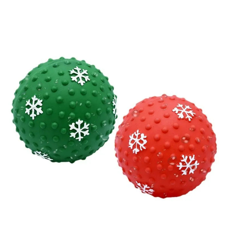 Red dog toy ball with snowflake print pattern, 7cm diameter, bouncing on grass