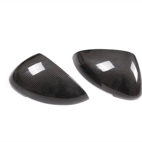 Pair of black true carbon fibre rearview mirror covers for Porsche Macan on a white background.