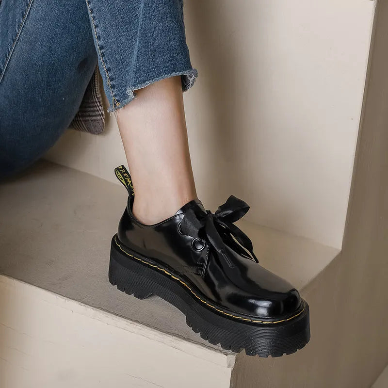 Women's black thick-soled leather shoes with cross strap design and lace-up closure