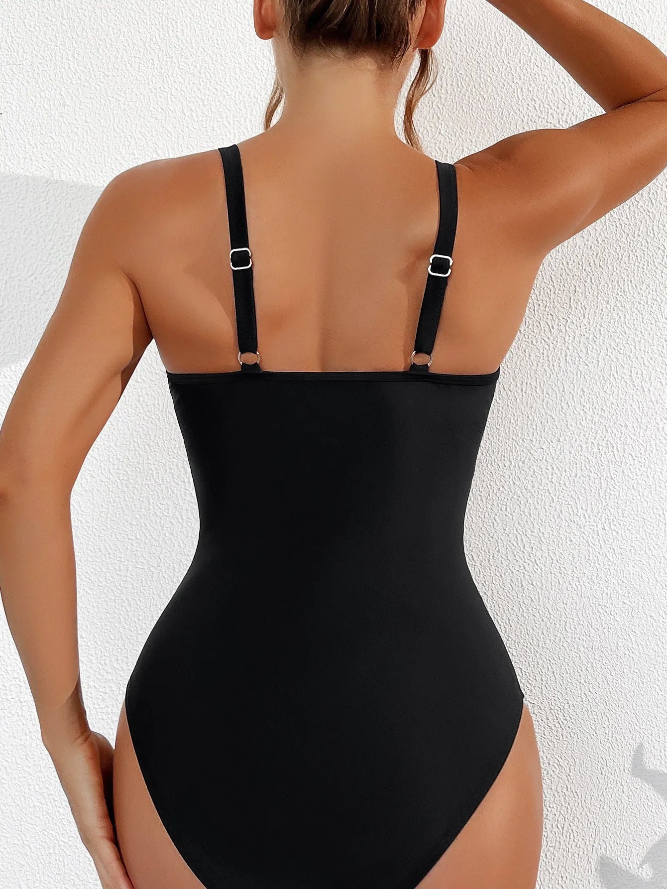 Black halter neck one-piece swimsuit for women on a mannequin, showing sleeveless design and briefs style.