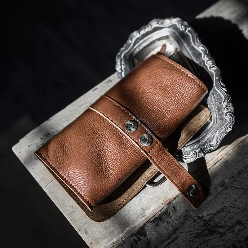 Handmade vintage style leather wallet in black, showing tape extraction closure.