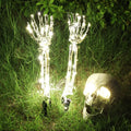 Halloween LED skeleton arm ground plug lamp in purple with LED glow placed on grass