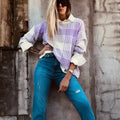 Lilac plaid print loose sweater with ribbed trim and long sleeves on a hanger