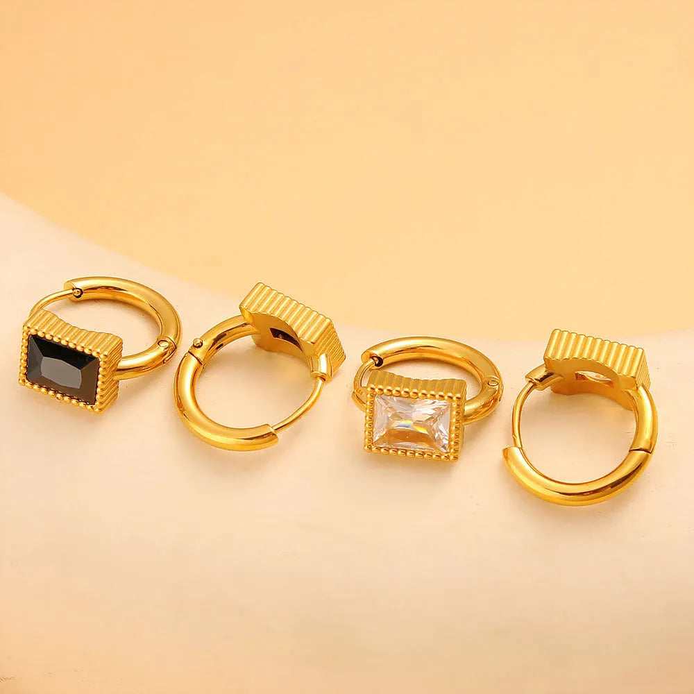 Square stainless steel earrings with round ring design elements in white, black and green colour options