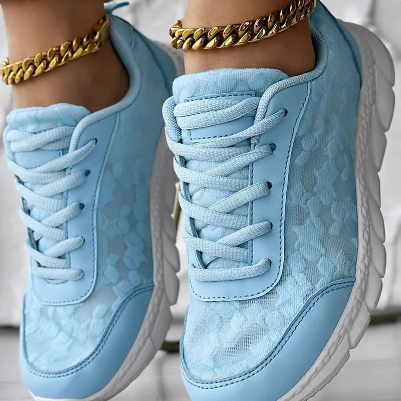 Women's white canvas casual sports shoes with a round toe and flat soft sole on a plain background.