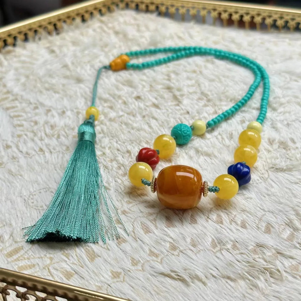 Turquoise lucky pendant necklace with hand-woven mesh flower design on an adjustable ball bead chain.