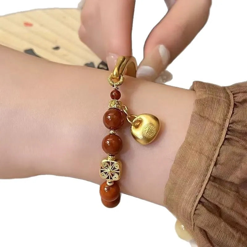 Golden South Red Agate Character Ingot Bracelet with lucky bag charm on a white background
