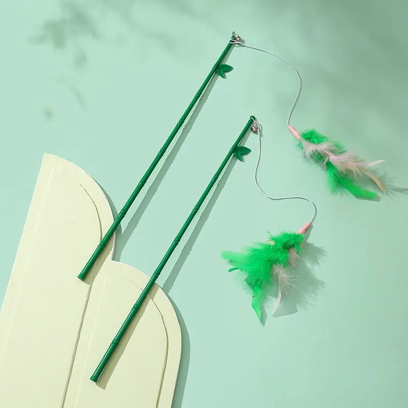 Interactive cat toy feather wand with green bells and feathers on a durable wand