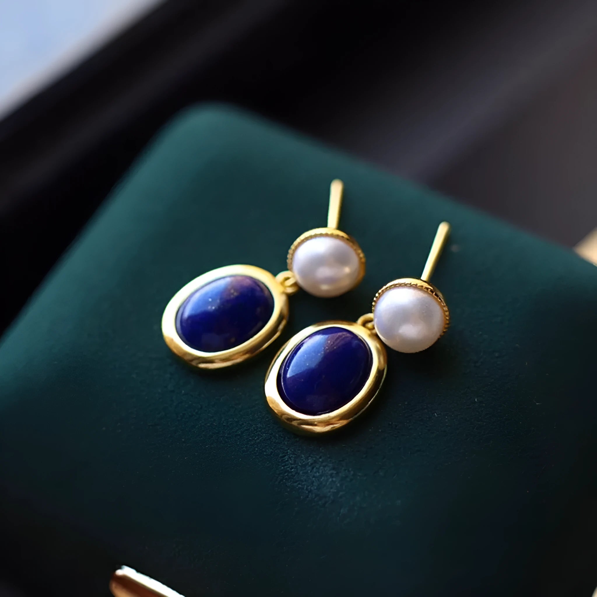 A pair of simple 925 silver earrings with blue lapis lazuli pearls and auspicious patterns.