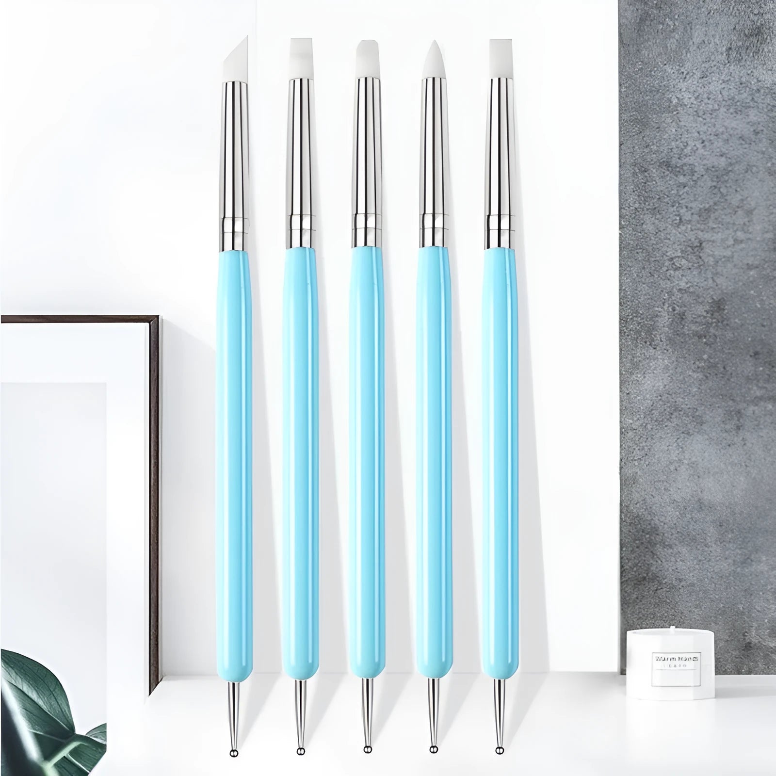 Five blue silicone double point electric drill pens for manicure painting set on light background