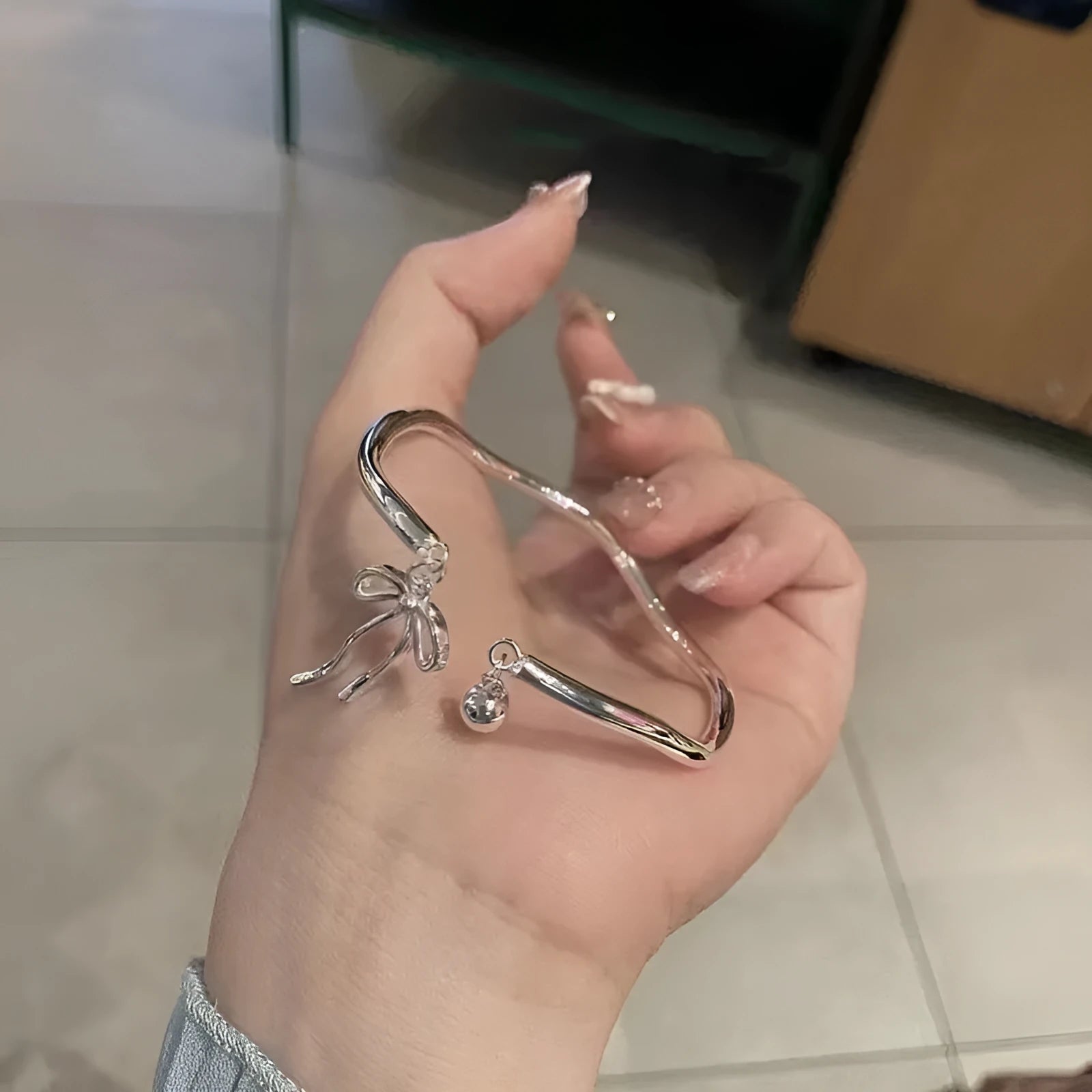 Silver adjustable bow bracelet with bowbell clasp on adjustable chain