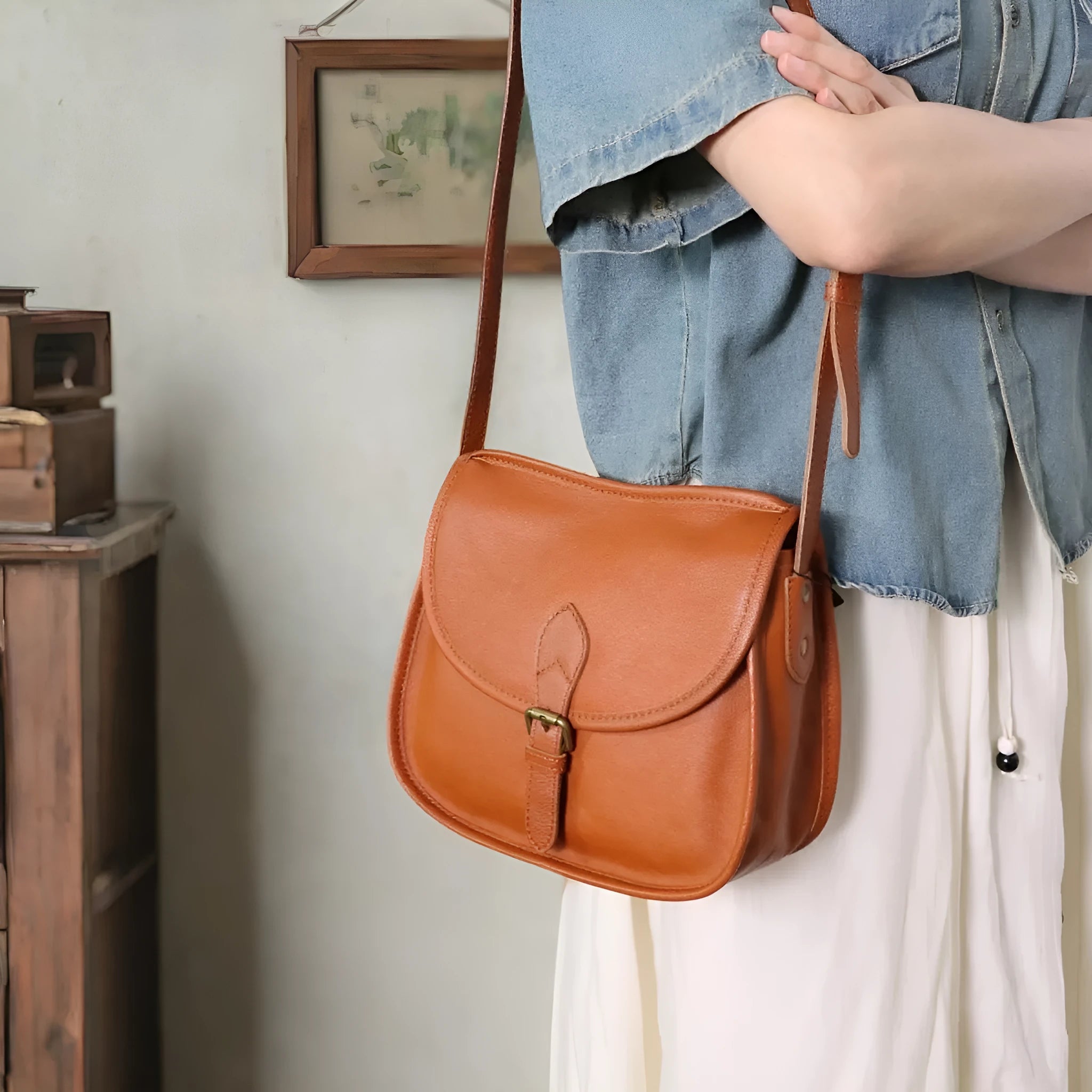 Genuine leather messenger bag in brown, soft shell shape with flap closure and visible sewing detail