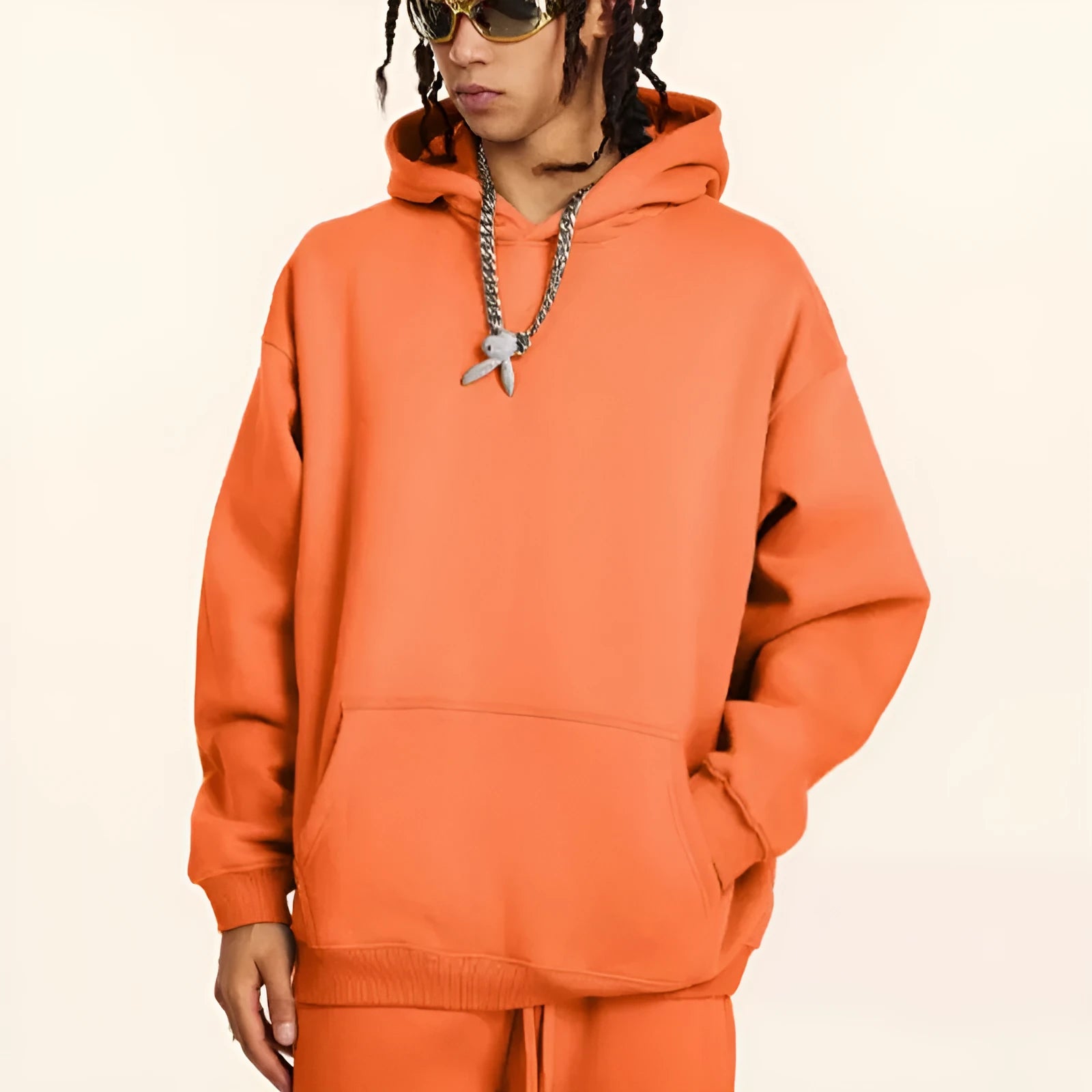 Man wearing a loose fit grey cotton terry hooded sweater with drop-shoulder sleeves.