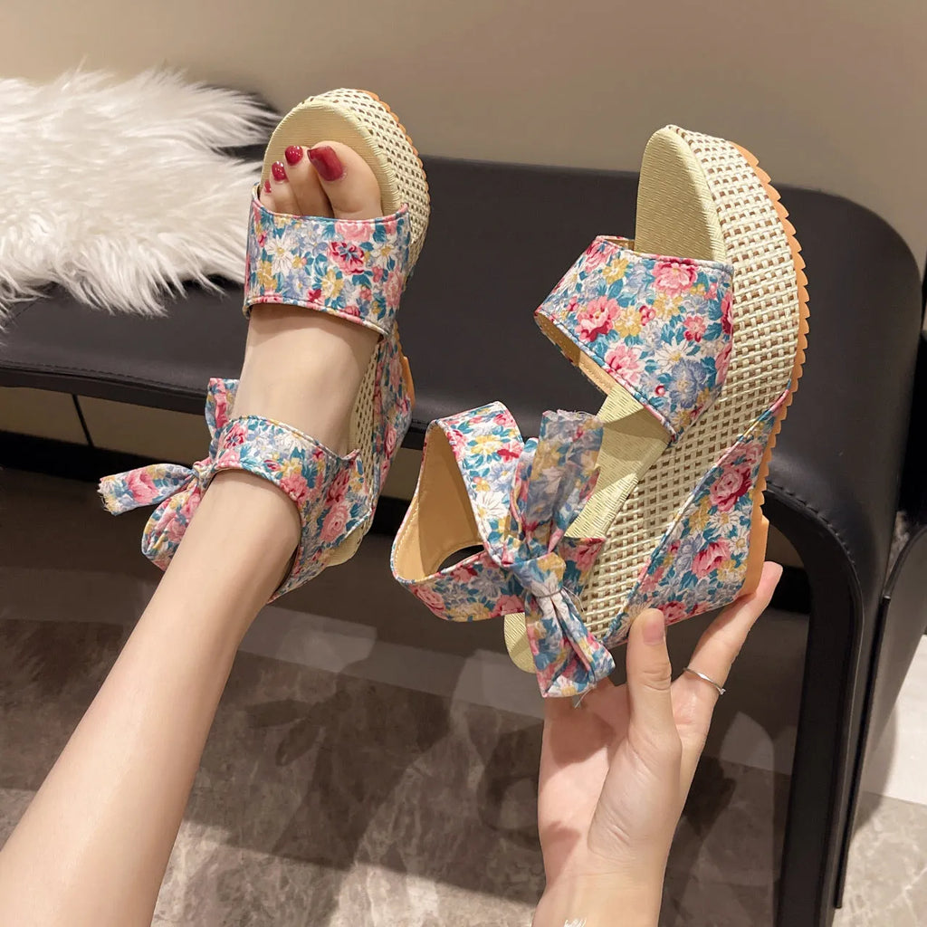 Women's wedge peep toe sandals with ankle-strap buckle, cloth upper, and rubber sole in a floral pattern.