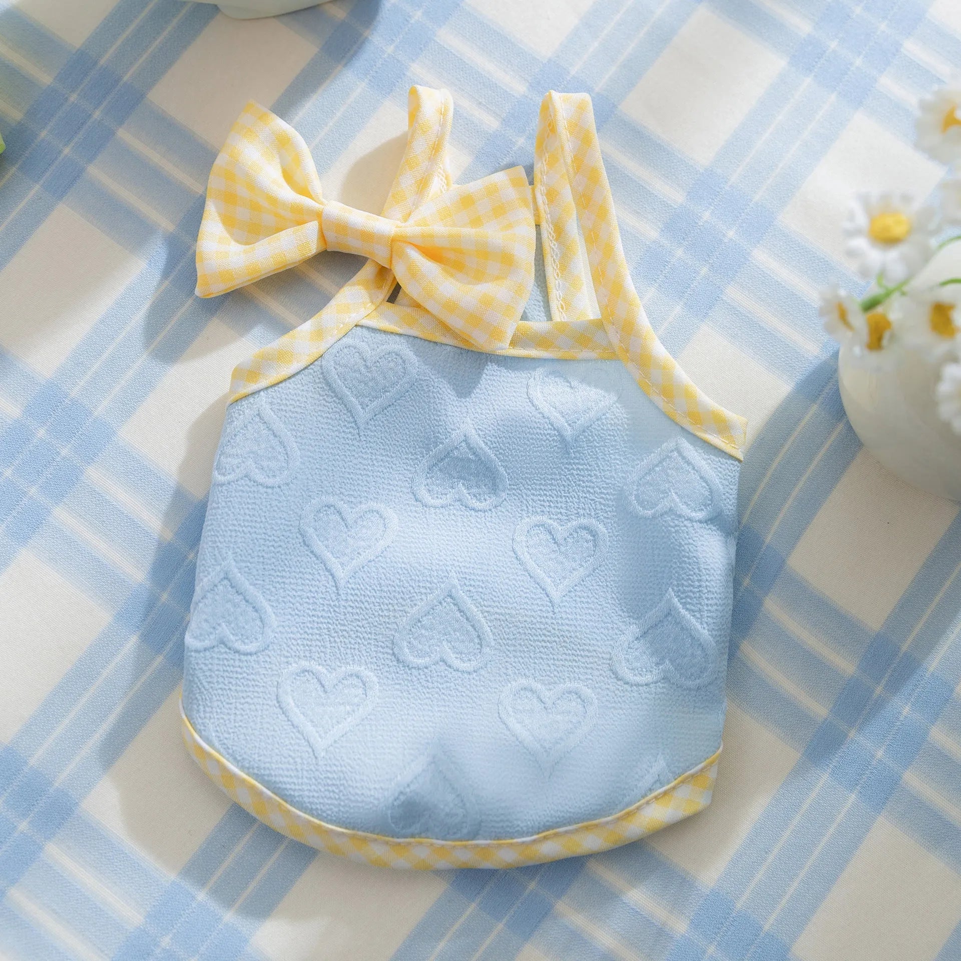 Small dog wearing heart texture vest with bow suspenders in blue colour