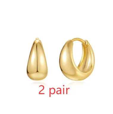 A pair of round, geometric brass earclip earrings with a gold electroplated finish.
