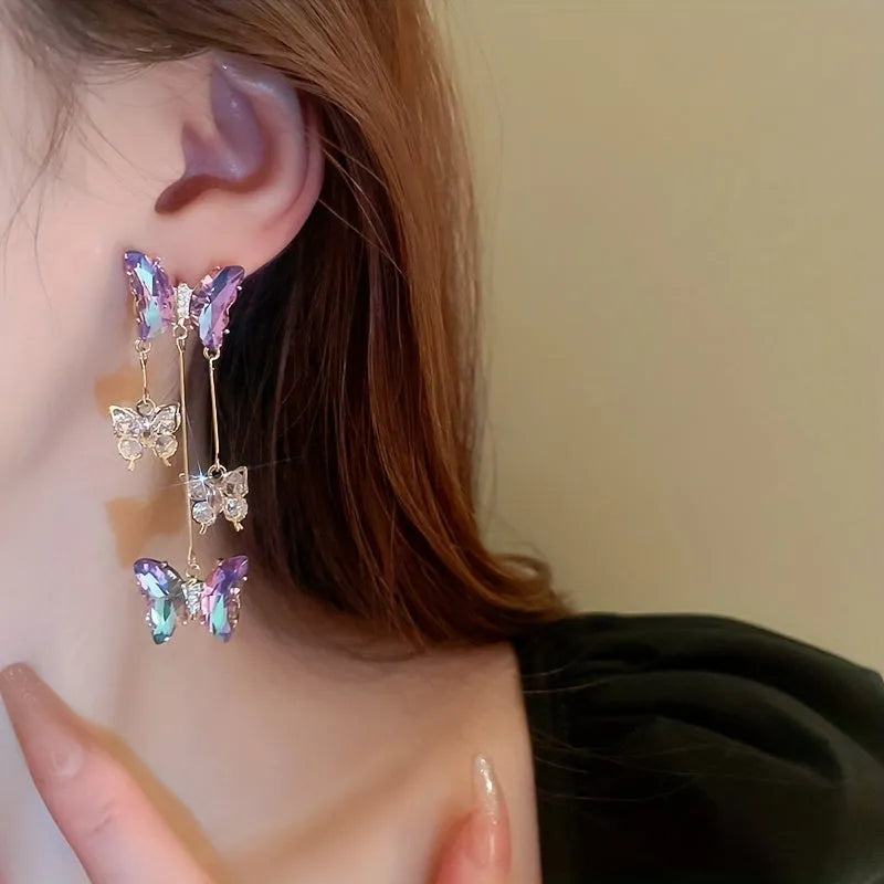 Close-up of women's silver needle blue purple butterfly tassel earrings with crystal flowers on alloy.