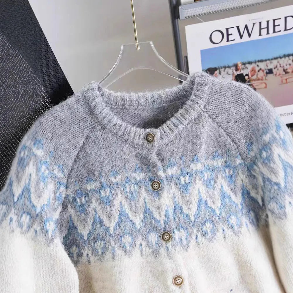 Women's beige jacquard knit sweater coat with loose fit and long sleeves on a hanger.