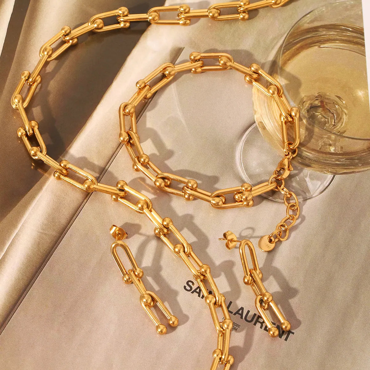 Stainless steel jewellery set including a necklace with titanium steel pendant, bracelet, and earrings in a matching colour