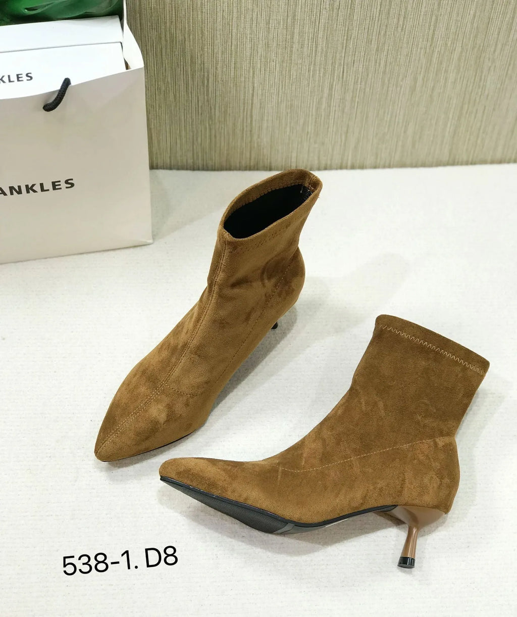 Women's black pointed toe ankle boots with a stiletto heel on a plain background