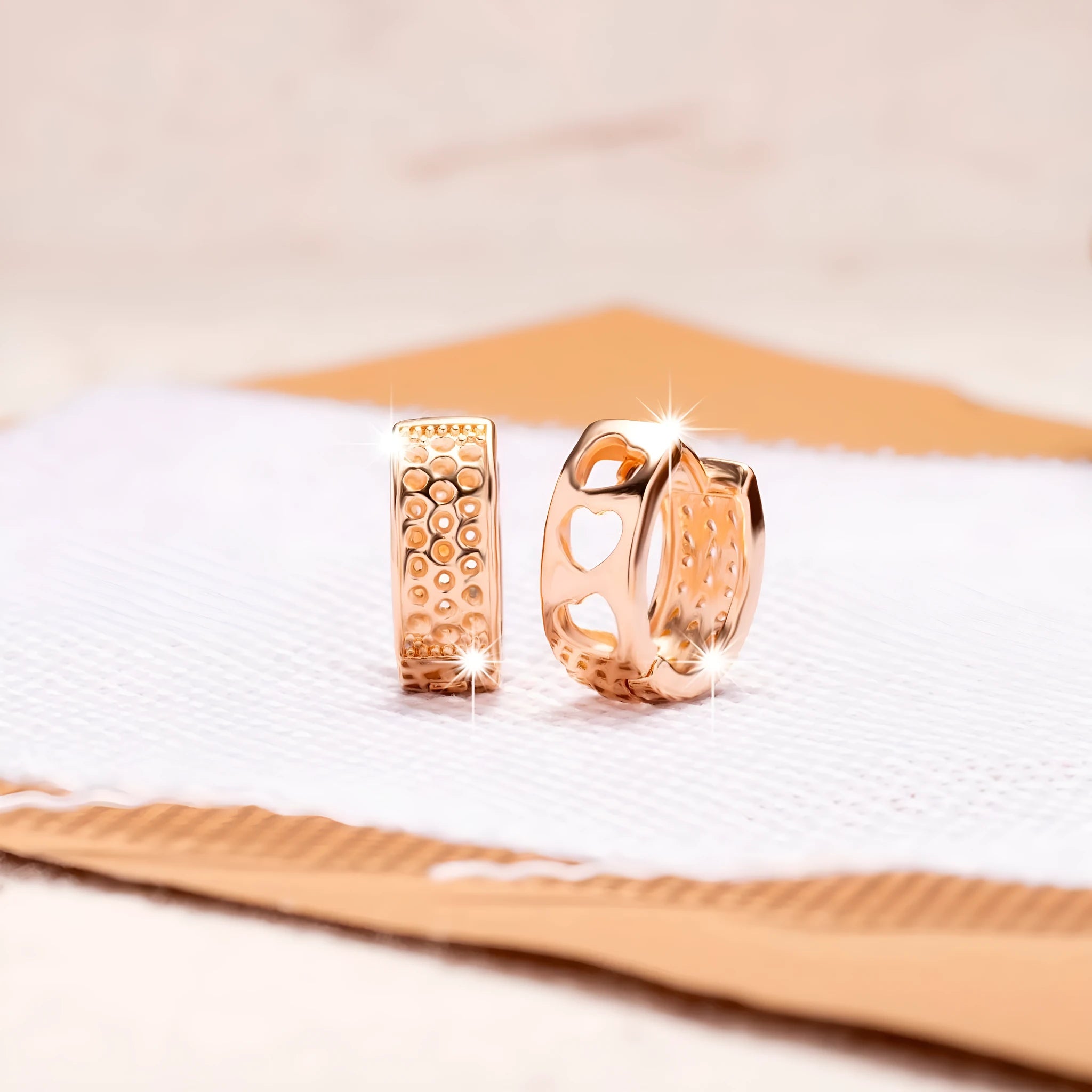 Rose gold circular earrings with three hollow heart cut-outs