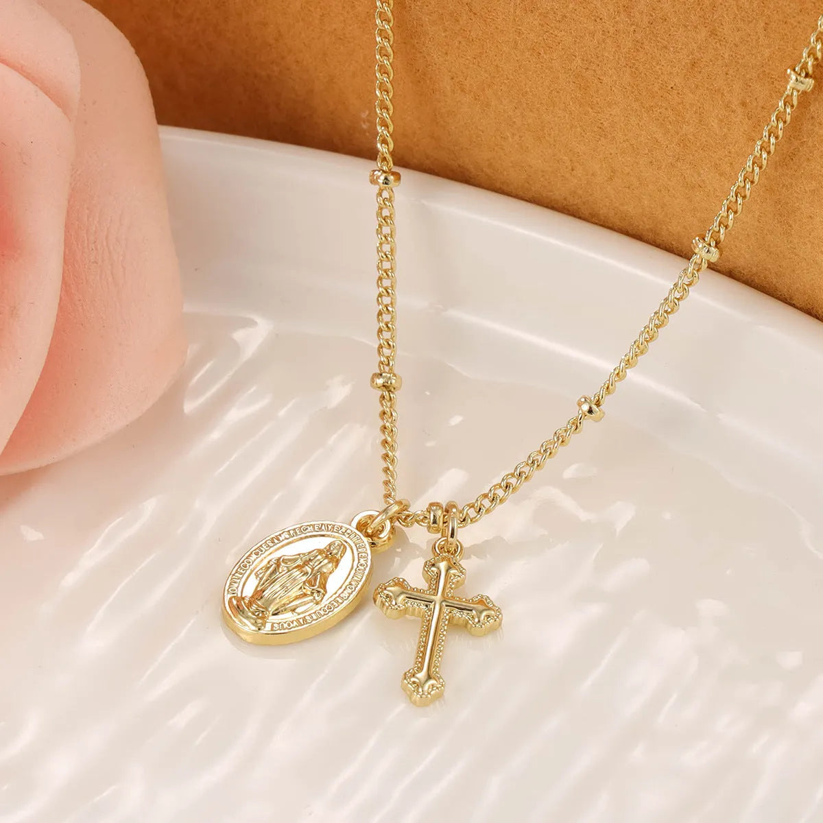 Gold geometric cross Virgin Mary necklace for women on display