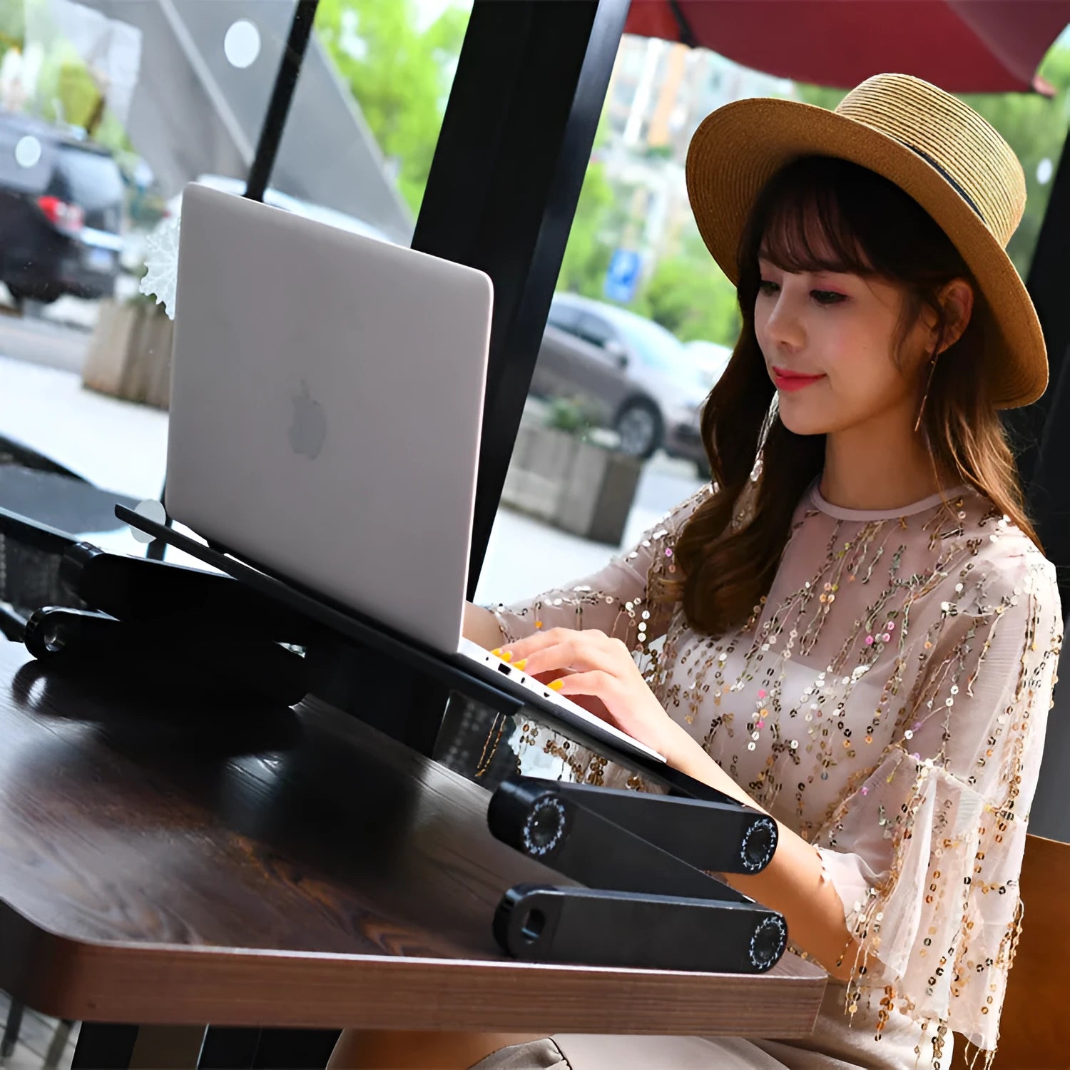 Black folding metal laptop desk with cooling fan on sofa with laptop