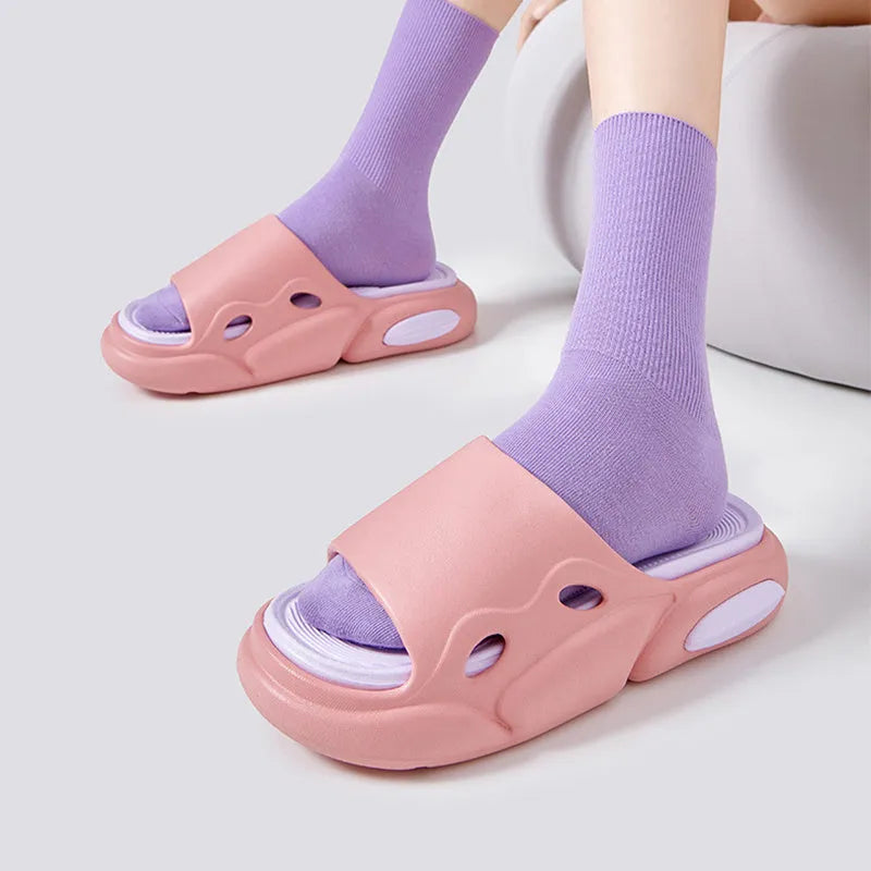 Two-colour couple slippers showing thick EVA sole and round toe, displayed in black and white colourway.