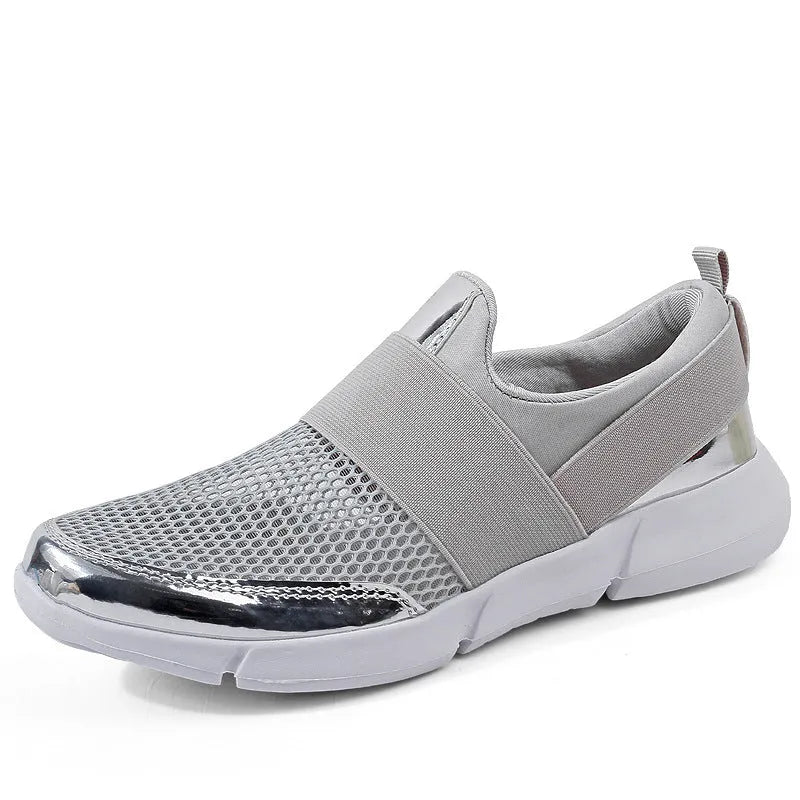 Blue low-top women's mesh sneakers with a casual design on a hard floor surface.
