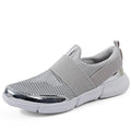 Blue low-top women's mesh sneakers with a casual design on a hard floor surface.