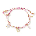 Close-up of a colourful hand-woven braided rope bracelet with a carrying strap tag on a woman's wrist.