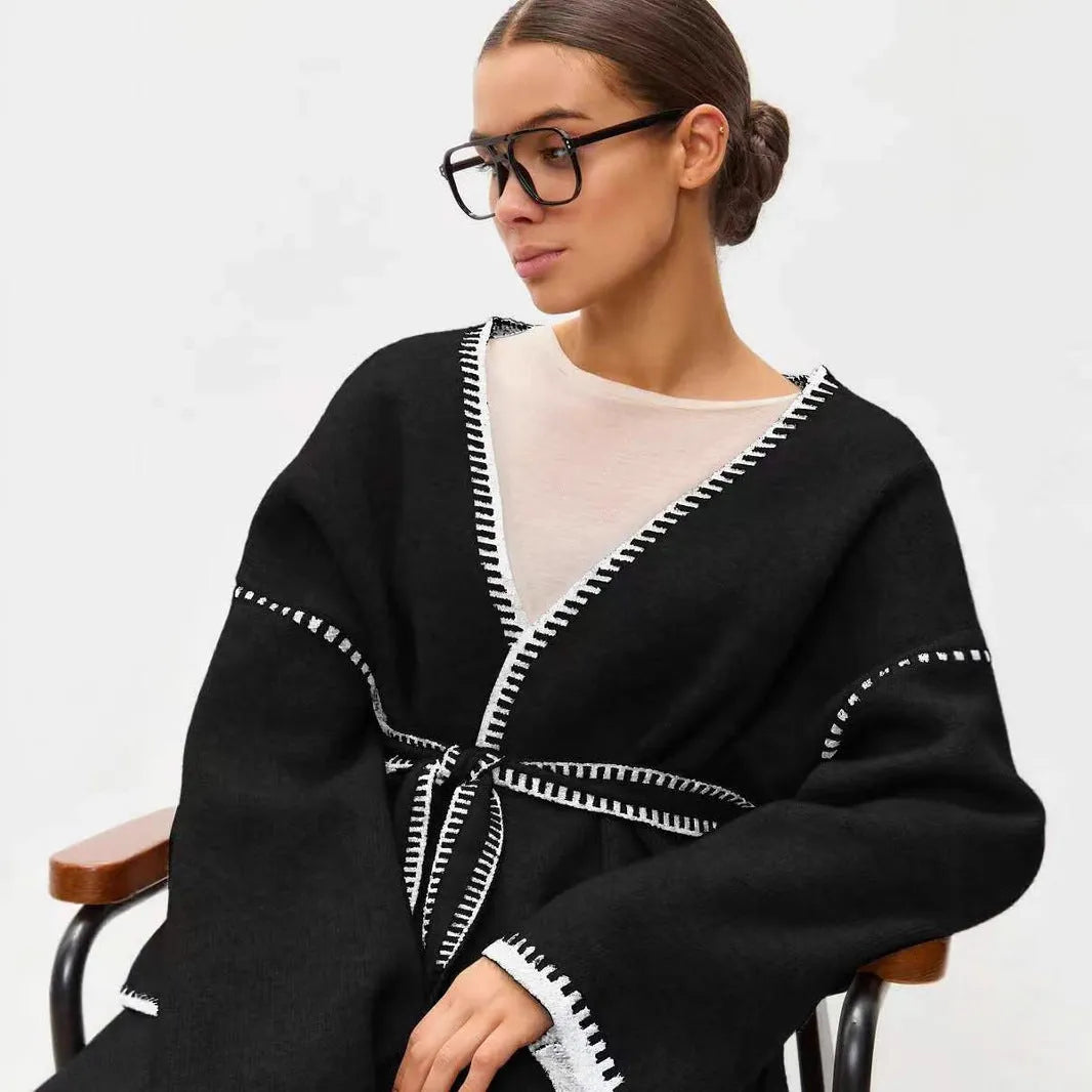 Loose knit camel coloured cardigan sweater with long sleeves on a hanger