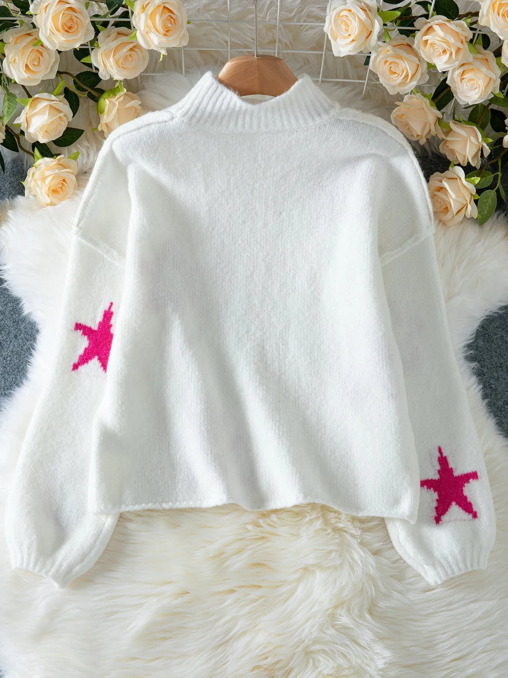 Women's white loose turtleneck pullover sweater with a black five-pointed star pattern on the front.