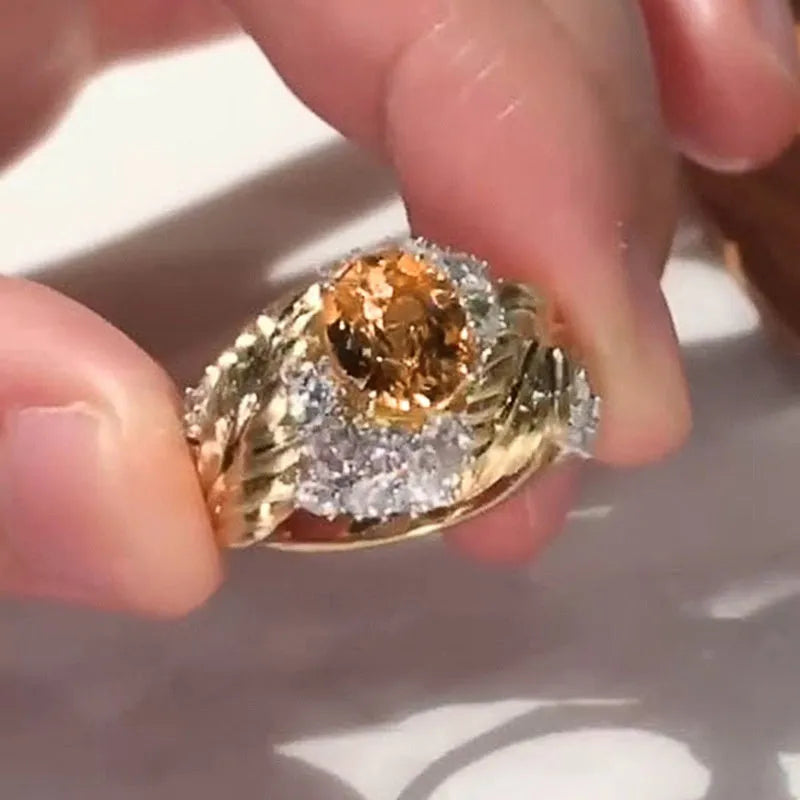 Yellow gold colour women's ring with an embossed feather design and a small inlaid zircon stone.