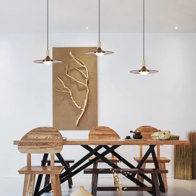 Walnut wood fish line chandelier with all-copper accents against a light background