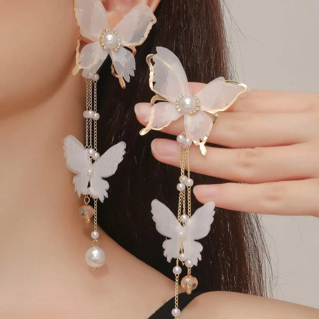 White butterfly earrings with pearl and rhinestone details and tassel design