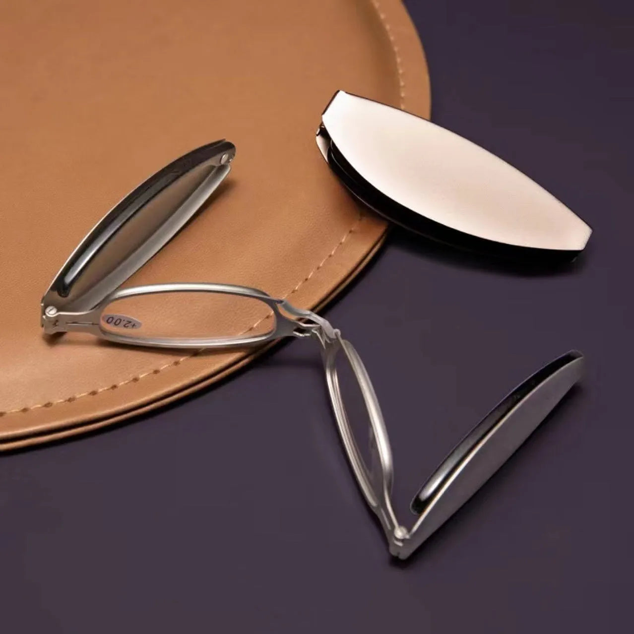 Folding presbyopic glasses in black frame showing collapsed and open positions with retro ring detailing