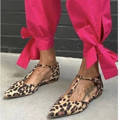 Leopard print women's pumps with pointed toe, low chunky heel, and cross shoulder straps.