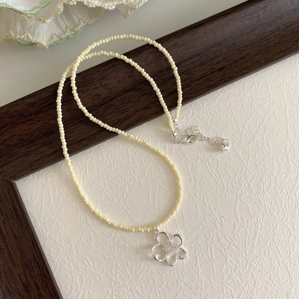 Women's colourful beaded hollow flower necklace with copper pendant, electroplated finish, on display.